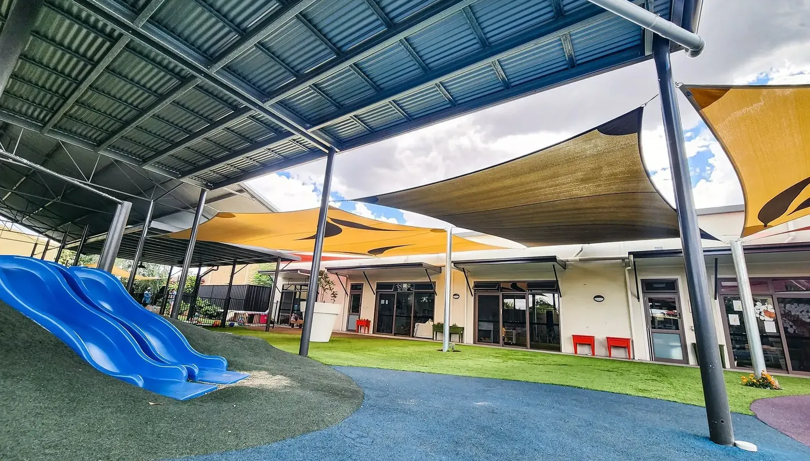 Childcare centre shade sail shading a slide and soft-fall play equipment - New England Shade Sails, Tamworth