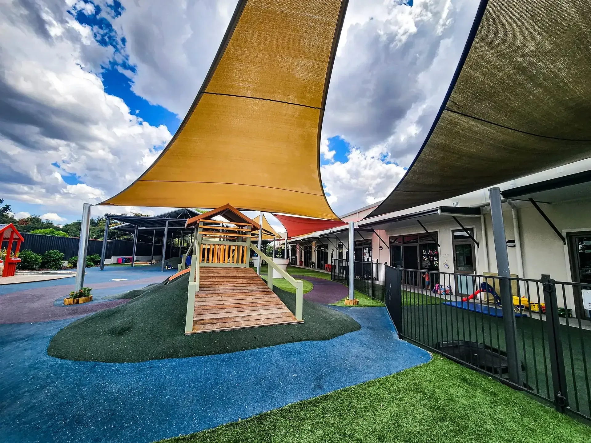 Colourful childcare centre shade sails over a soft-fall playground - New England Shade Sails, Tamworth