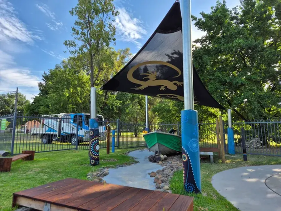 Black shade sail over a childcare playground with timber decking - New England Shade Sails, Tamworth