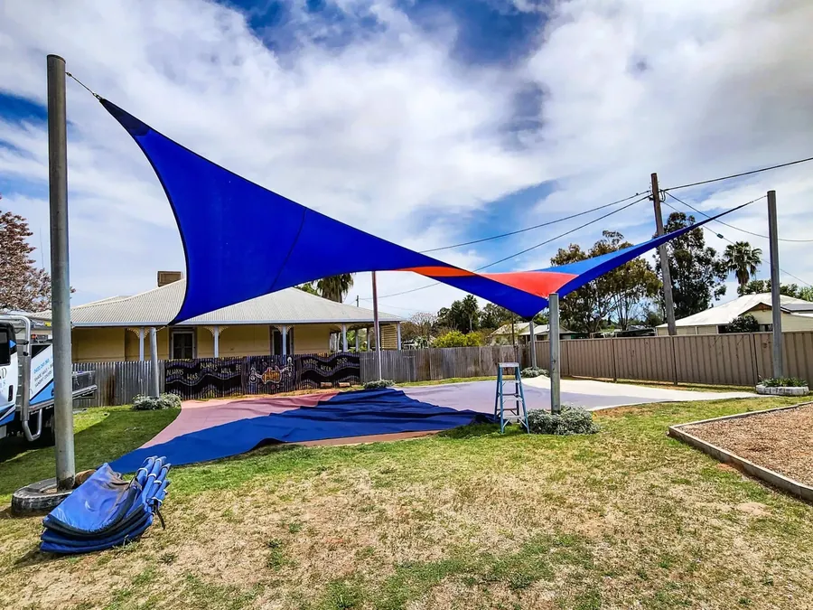 Bright blue shade sail shading a childcare play area with a slide - New England Shade Sails, Tamworth