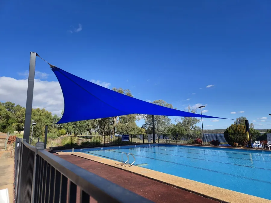 Blue shade sail over a poolside lounge area at a country property - New England Shade Sails, Tamworth