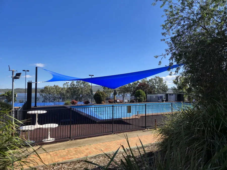 Blue shade sail shading seating beside a public swimming pool in the New England region - New England Shade Sails, Tamworth