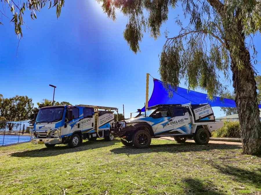 Blue shade sail installed beside work vehicles at a rural property - New England Shade Sails, Tamworth
