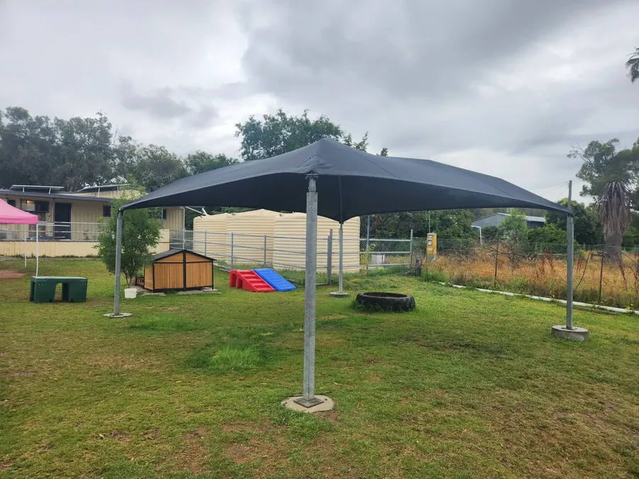 Charcoal shade sail shading a grassed childcare play yard - New England Shade Sails, Tamworth