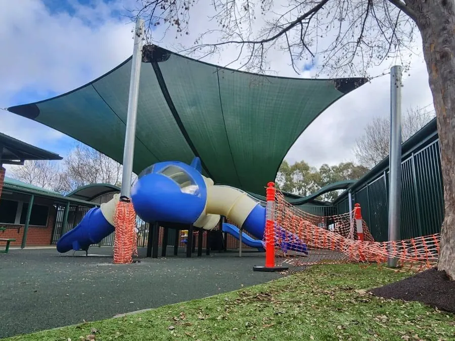 Green shade sail over a school playground with climbing equipment - New England Shade Sails, Tamworth