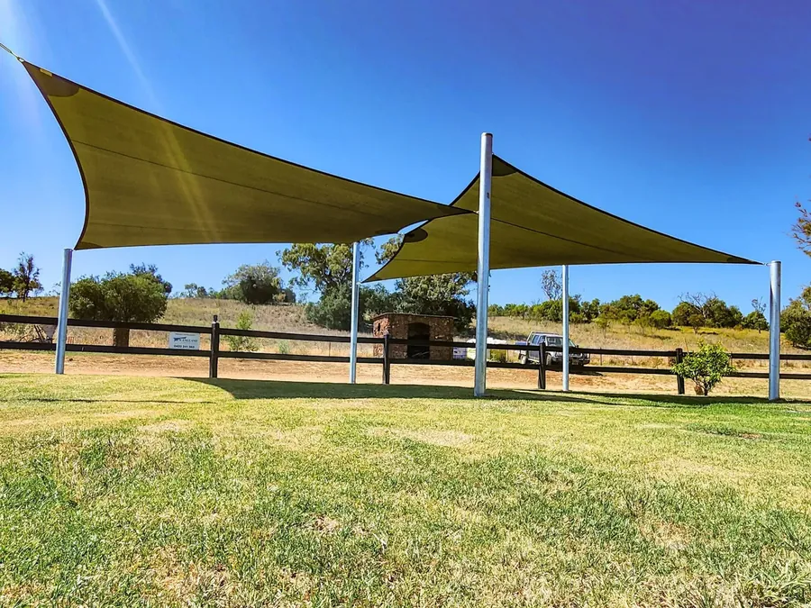 Olive shade sail on tall posts in an open paddock at a rural property - New England Shade Sails, Tamworth