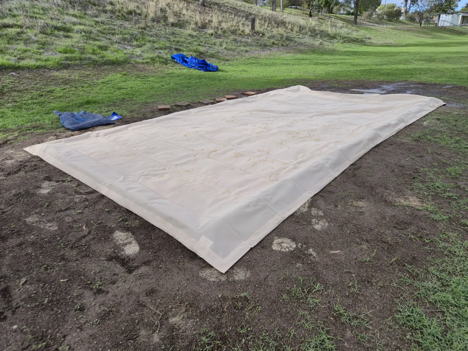 Sand coloured shade sail fabric laid out flat on grass before installation - New England Shade Sails, Tamworth