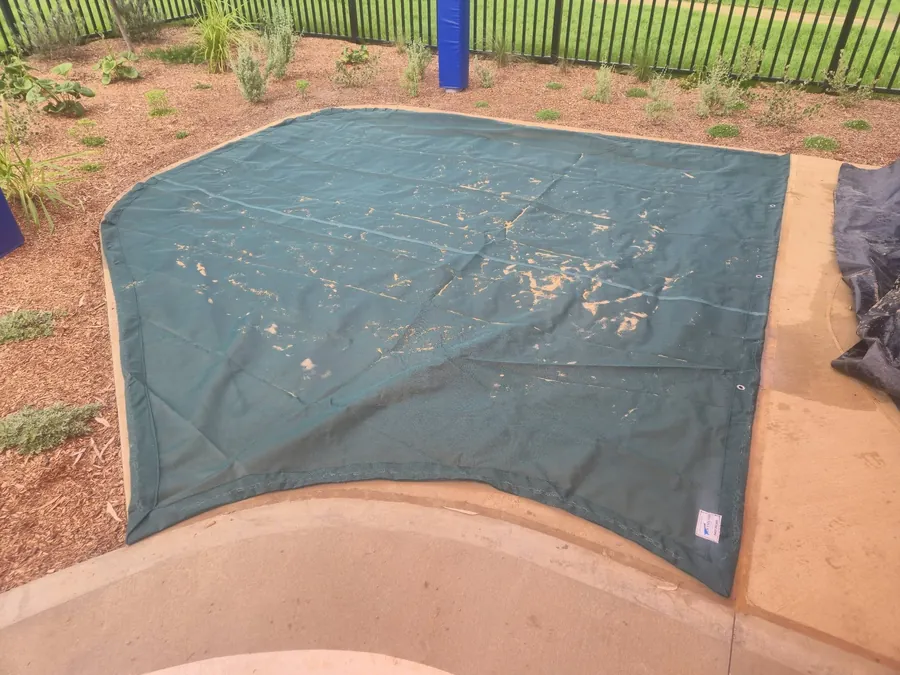 Green shade sail stretched above a large sandpit at a childcare centre - New England Shade Sails, Tamworth