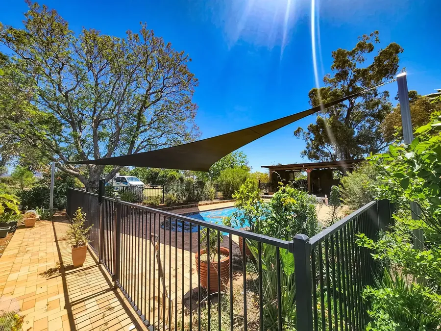 Shade sail over a pool fence and garden at a rural home - New England Shade Sails, Tamworth