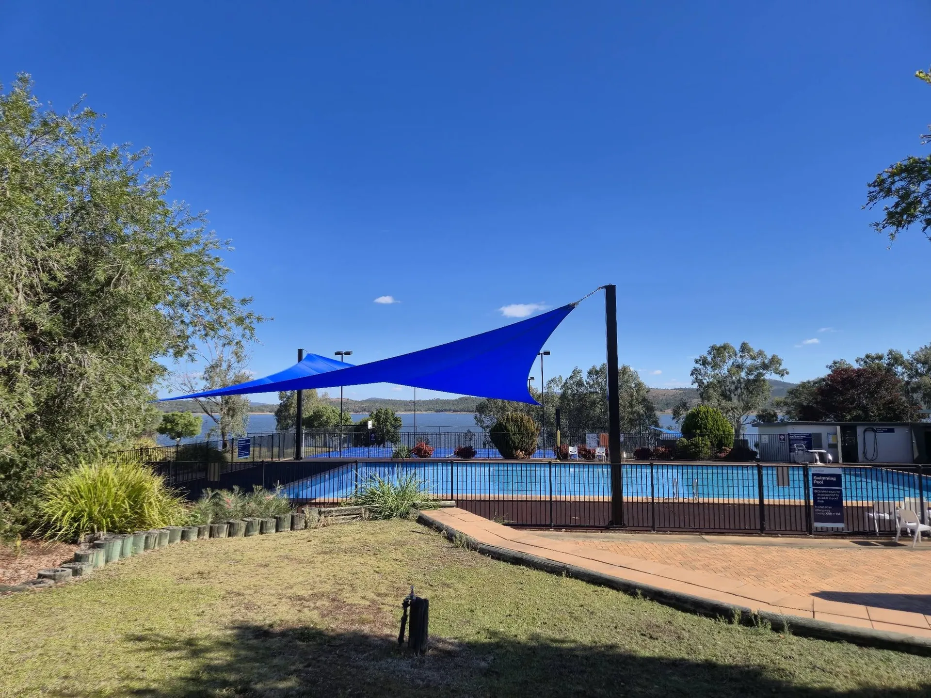 Blue custom shade sail installed over a backyard swimming pool at a home - New England Shade Sails, Tamworth