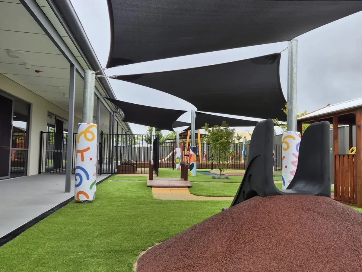 Padded shade sail posts protecting children under black shade sails at a Tamworth childcare playground - New England Shade Sails, Tamworth