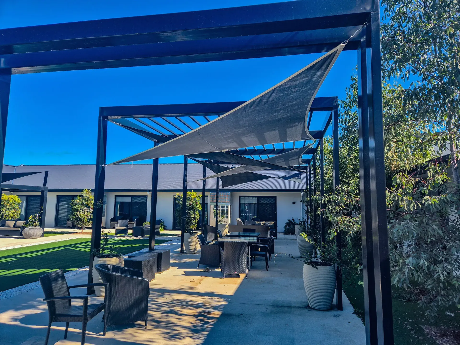 Custom shade sail shading an alfresco dining patio at a modern home - New England Shade Sails, Tamworth