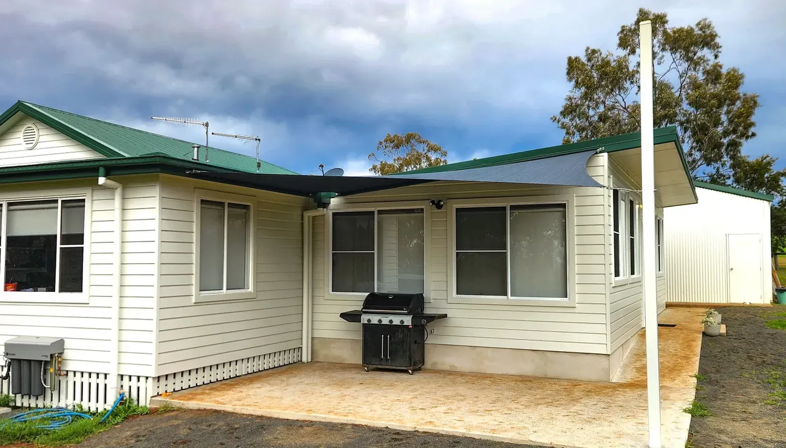 Shade sail posts installed beside a weatherboard home outdoor area in Manilla - New England Shade Sails, Tamworth
