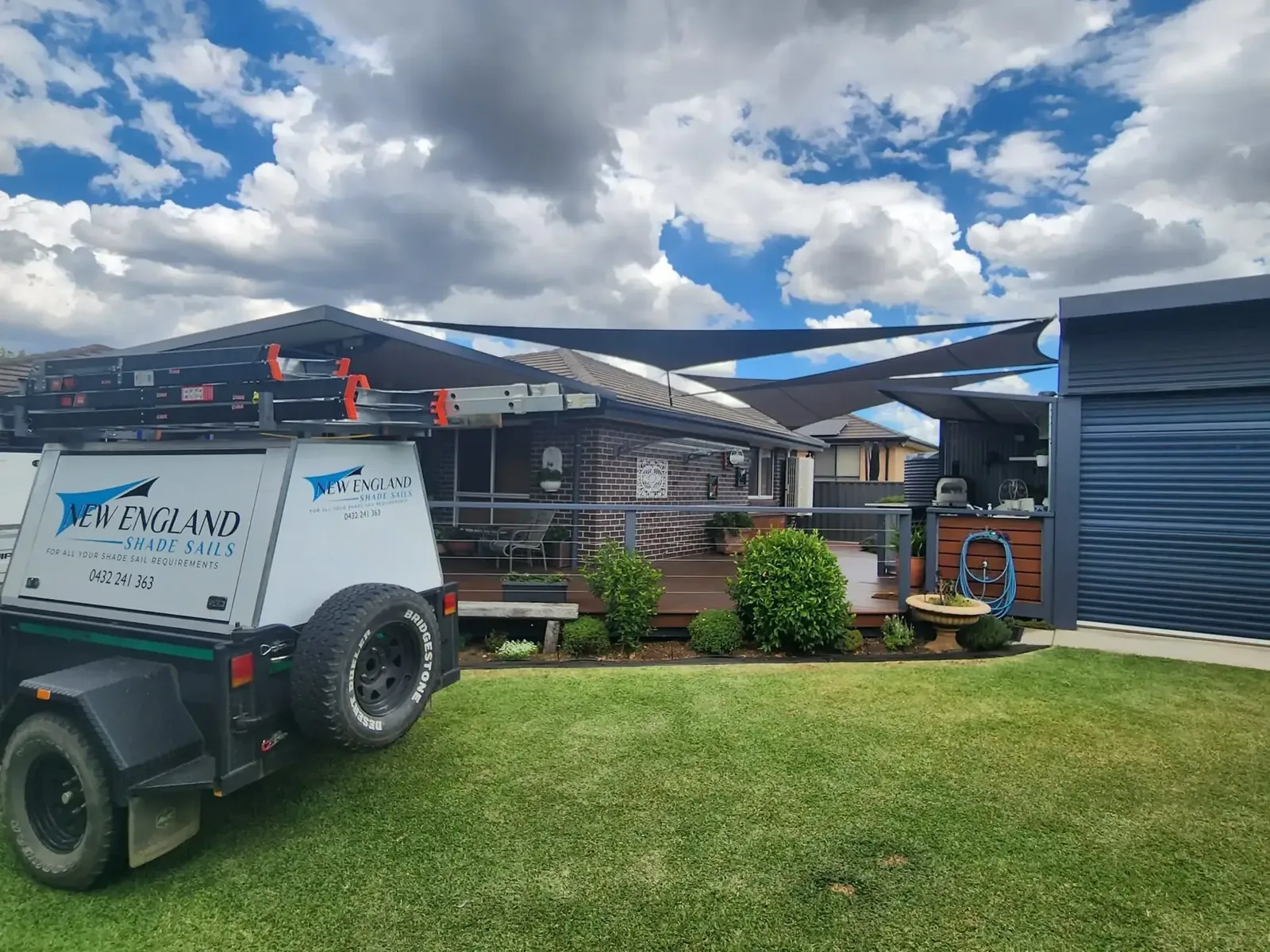 New England Shade Sails work trailer beside charcoal shade sails over a home deck - New England Shade Sails, Tamworth