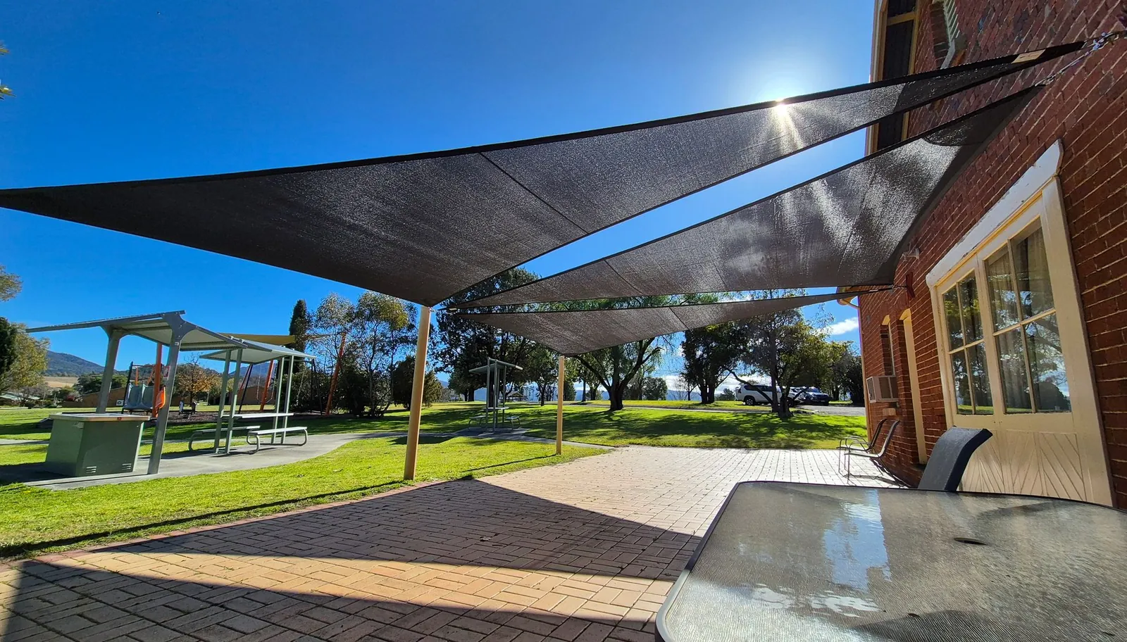 Charcoal shade sail shading a paved outdoor dining area at a home in Quirindi - New England Shade Sails, Tamworth