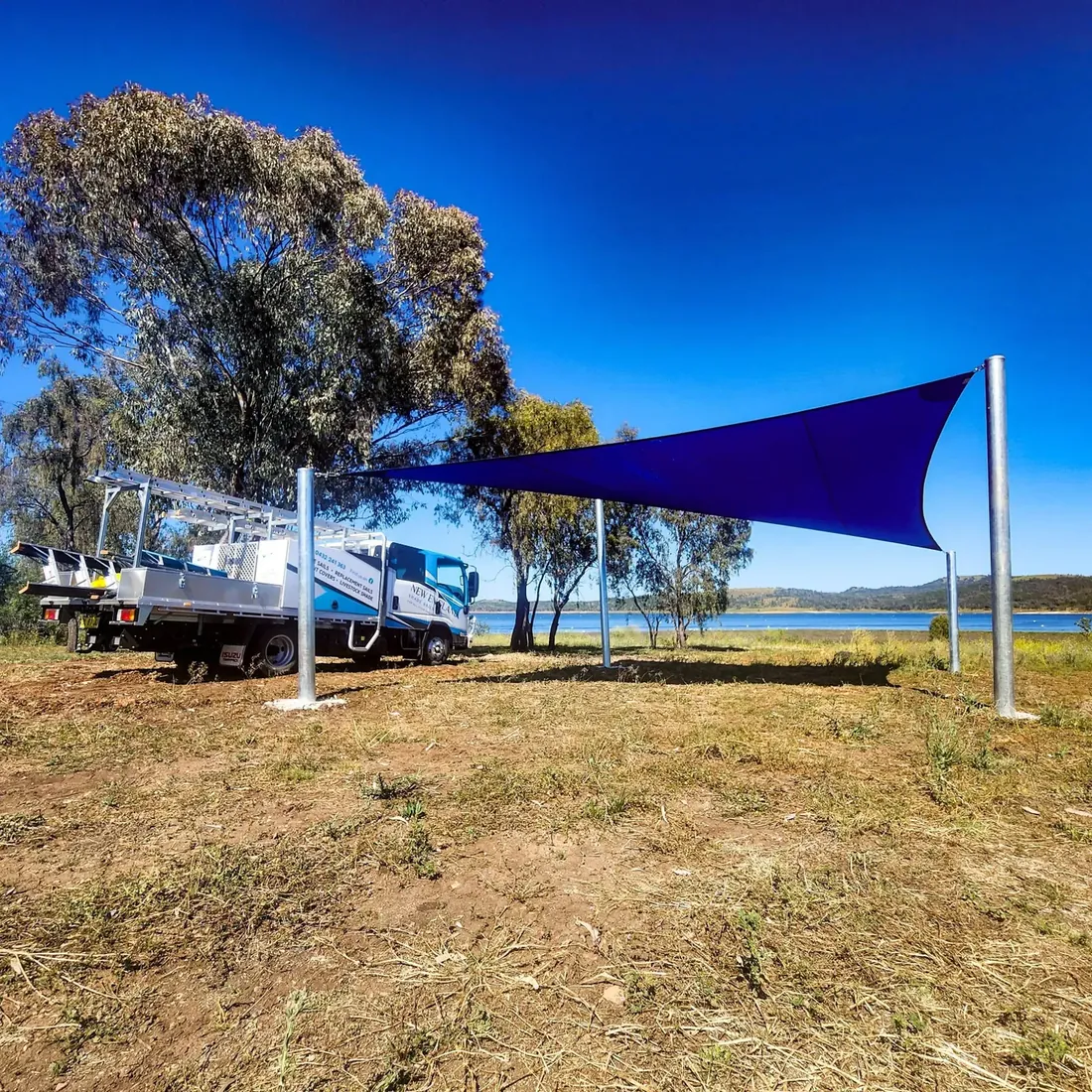 Bright blue custom shade sail installed on galvanised steel posts at a New England property - New England Shade Sails, Tamworth